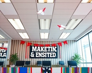 joyous festive marketing, inspired, strategizing, photorealistic, conference room with holiday banners, highly detailed, floating paper planes as if symbolizing ideas, clear resolution, pastel shades, overhead fluorescent lighting, shot with a macro lens.
